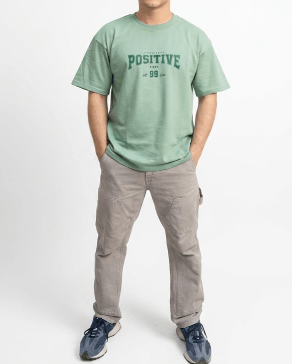 Sage green oversized positive print unisex t-shirt front view with premium streetwear design