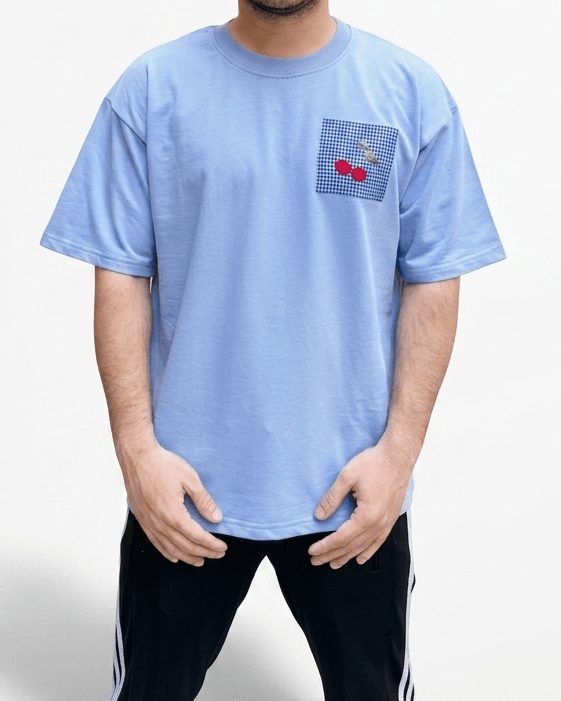 Close-up view of the embroidered design on a sky blue oversized premium cotton T-shirt.