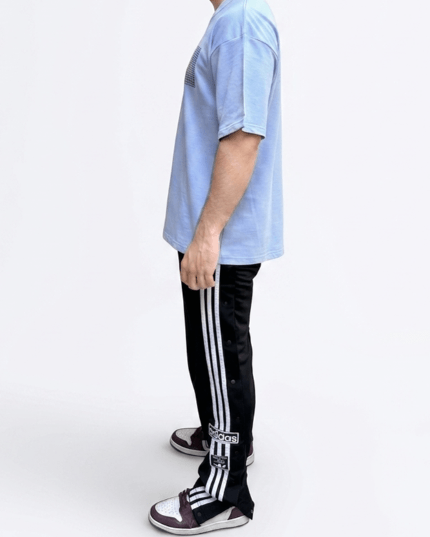 Side view of a sky blue oversized embroidered T-shirt showcasing the relaxed streetwear silhouette.